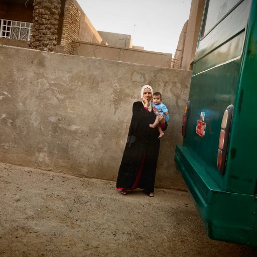 A woman brings her child outside their home momentarily, as it is only safe when the U.S. military is present, in the al Doura district of Baghdad, Iraq on June 5, 2007. Life in al Doura has become worse since two Iraqi National Policemen, former members of the pro-Shiite Badr Brigades, had set up a check point outside the neighborhood and began shooting civilians, including women and children, because they were Sunni.