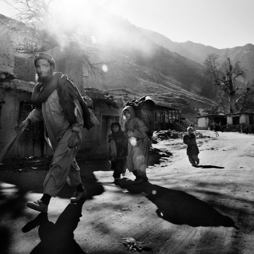 A local family walks on the street in Weredish village, Pech Valley, Kunar province, Afghanistan on Dec. 21, 2009. Daily life goes on seemingly normal in these areas even though there are a series of U.S. bases along the river valley, the largest of these being Camp Blessing, located near Nangalam at the junction of the Pech river with the Waygal River.