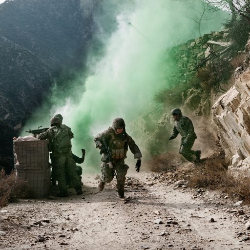 Soldiers of 2nd Platoon, Baker Company, 2nd Battalion, 12th Infantry Regiment return fire after they were attacked by insurgents during an operation in Loy Kalay village in the Korengal Valley, Kunar province, Afghanistan on Dec. 29, 2009. The green smoke is used to camouflage and protect the soldiers from enemy fire. Patrols in this region come under daily attack from Taliban fighters and local insurgents.