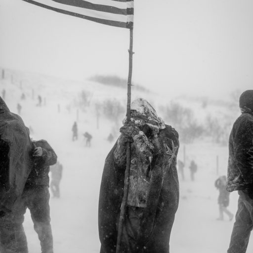 Cannonball, North Dakota - December 5, 2016: A protester holds an American flag during a demonstration near the Standing Rock Indian Reservation in North Dakota during the NoDAPL protests efforts. Photo: Christopher Lee.