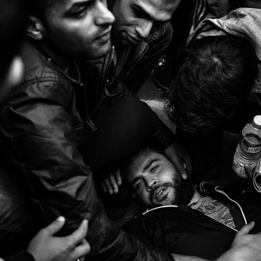 Berlin, Germany - September 23, 2015 A group of refugees helped a man, who according to them was struck in the head by German security while waiting in line to be processed at Landesamt für Gesundheit und Soziales or LAGeSo, the State Office for Health and Social Affairs for Berlin, which sees an average of 600 refugees and migrants a day. Here, legal documents to be in the country along with which shelter facilities they will be staying at are assigned. Once the refugees and migrants have received legal documents to remain in country, they have the option of staying in a shelter or opting for their own housing. Expecting to have 1 million migrants and refugees by the end of the year, Germany is struggling to keep up with the overwhelming numbers which lead to longer processing times and strong handed handling by security forces. Credit: Christopher Lee