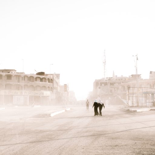 Mosul, Iraq - May 17, 2017: Local civilians walk down one of the main roads in a west Mosul neighborhood that was recently liberated from ISIS. Photo: Christopher Lee.