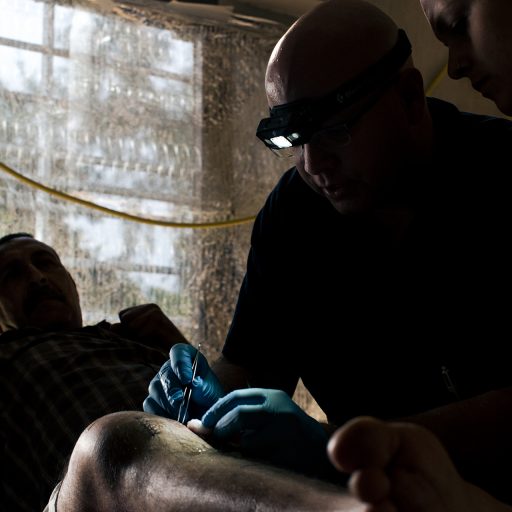 Mosul, Iraq - April 27, 2017: Chris Summers, a cardiotherasic physisian assistant from Long Island, New York, stitches a bullet wound of an Iraqi civilian at a trauma stabilization point or TSP in a neighborhood near the frontline in western Mosul. Credit: Christopher Lee for The New York Times.