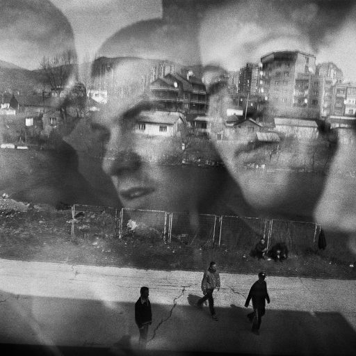 Albanian schoolkids look out of a window reflecting the Serbian side of Mitrovica, a city in northern Kosovo badly affected during the Kosovo War, in 2000.