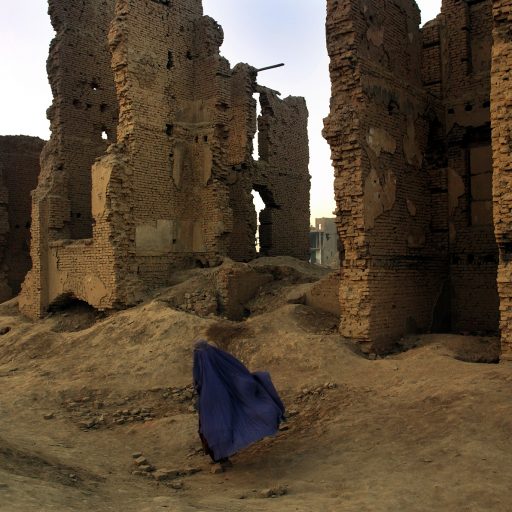 Women in a traditional burka heading to her home within the ruined city sections of Gada-e-Mawaind, Kabul. The area, like much of Kabul,was totally destroyed by decades of war. Thousands of Kabul residents live within these shattered remains in the Afghan capital.