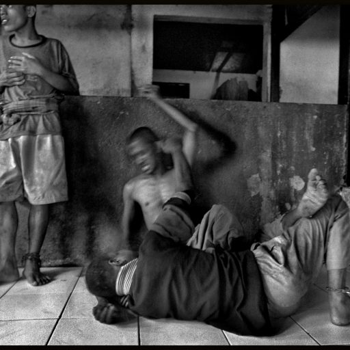 Jakarta, Indonesia. Chained drug addicts fighting at the Masjid Nurul Alam. Frustrated by the growing number of drug addicts and the rise of HIV/AIDS, the imam of this mosque resorts to chaining up drug addicts for up to six weeks in how they kick the needle.