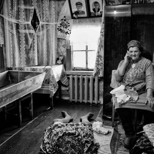 Nyna Vasylyevna Kurynoy is seen on the phone informing the relatives about the death of her mother in law - Ulyana Prokopovna, 96 years old - the oldest woman in Straholesie near Chernobyl's exclusion zone.