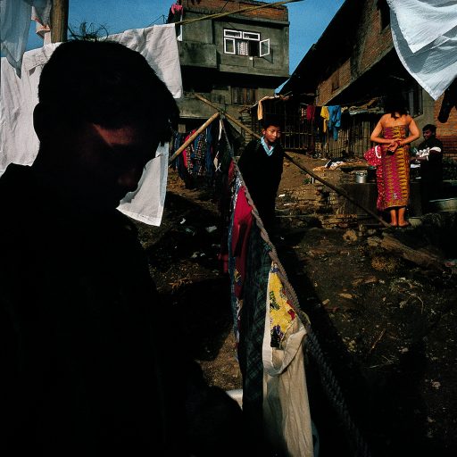 Boy walks through outdoor laundry in a slum near downtown Kathmandu, Nepal. Hand-washed laundry is a big business in the capital because of all the big hotels and people who can afford to have their laundry done, a big business.