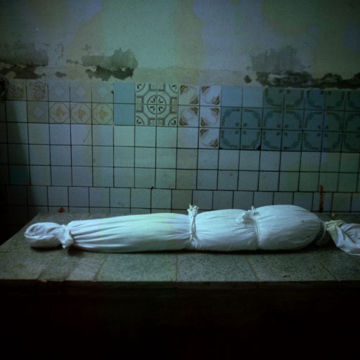 The body of a young Iraqi girl, wrapped in a white sheet, lays on the marble table of the wash room of a Shiite mosque's funerarium after she was killed by a bomb blast during U.S.-led coalition bombings over Baghdad, March 29, 2003.
