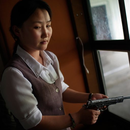 Behind the Curtains series — A North Korean woman loads a pistol for firing practice in Pyongyang, North Korea.