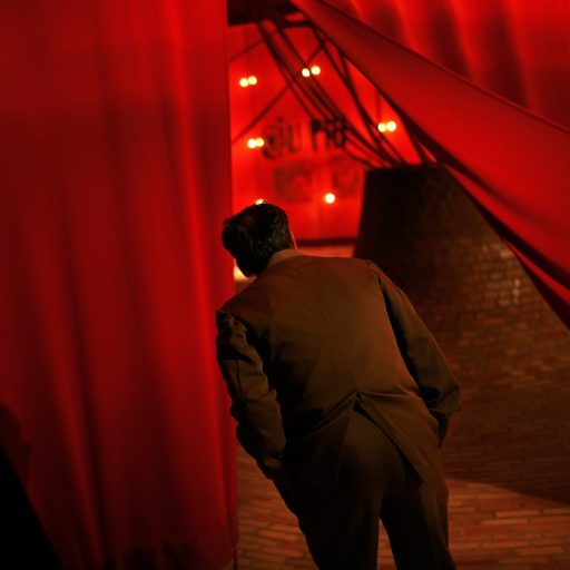 Behind the Curtains series — A man looks at an exhibit behind a red curtain inside the Ho Chi Minh Museum in Hanoi, Vietnam.