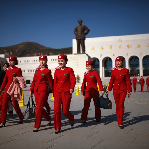 Behind the Curtains series — An all girls group of Young Communist League members walks past a statue of Chairman Mao Zedong in front of the Yan'an Revolutionary Memorial Hall in Yan'an, China. Yan'an is promoted as the "Revolutionary Holy Land" and offers a number of museums, monuments and other "Red Tourism" sites supported by the Chinese government.