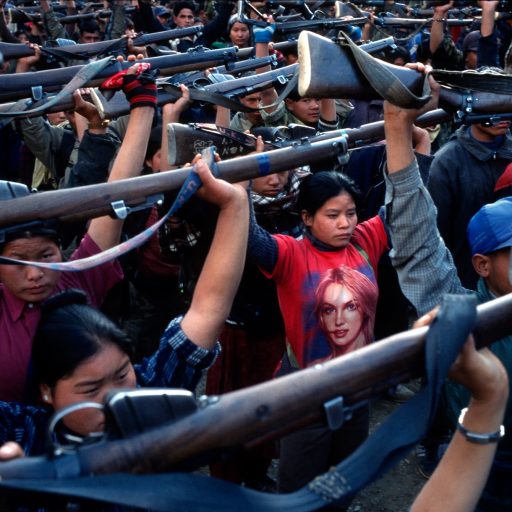 Behind the Curtains series — A Maoist rebel soldier wearing a Britney Spears t-shirt stands among a battalion of other soldiers of the People's Liberation Army during a drill in a schoolyard in the village of Gairigaon, Nepal.