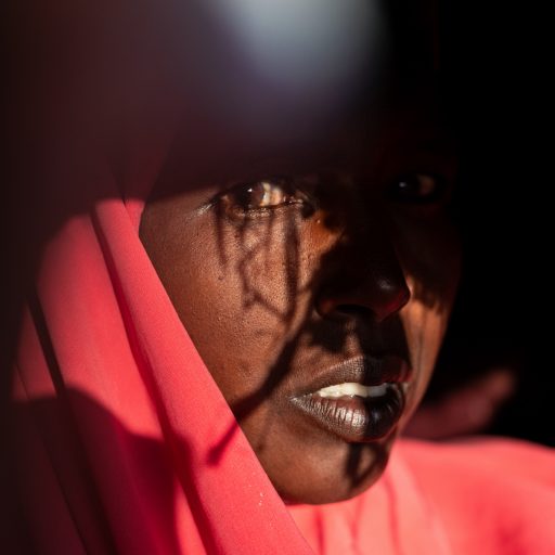 Portrait of Rahma Hassan Mahmoud (36) in Burao Airport IDP Camp outside Burao, Somaliland, on December 14, 2019. Rahma was a pastoralist in the village of Hayae in eastern Somaliland. Her family raised a herd of 300 goats and sheep and 20 camels. Then drought hit and within four weeks her entire herd was dead. “We were like a soul living on top of another soul,” Rahma said. When the goats died, the life she knew died with them. She and her family were forced to move to this IDP camp, and join what would become hundreds of thousands of people driven from their land.  

With the IOM predicting 200 million environmentally displaced people by 2050, countless Somalis will be pushed from their homes, with women and girls bearing the weight of displacement. Exacerbated by other factors, such as increased poverty, overcrowded and unsafe living conditions in temporary housing, loss of community, and increased power imbalances, Nichole documents how climate change has contributed to the increase of violence against women and girls.
