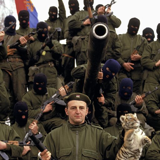 Serbian Tiger leader Zeljko Raznatovic or Arkan poses with his paramilitary unit, the Serbian flag, and a baby tiger that he liberated from a Croatian zoo in Erdut, Croatia. Arkan's Tigers were responsible for a large part of the ethnic cleansing that occurred at the beginning of the war in Bosnia.