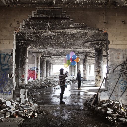 Young students visit the former Packard motor company building with balloons. They are gonna burst them to make sound recordings for a student project. The Packard plant is one of the most visited places in Detroit.