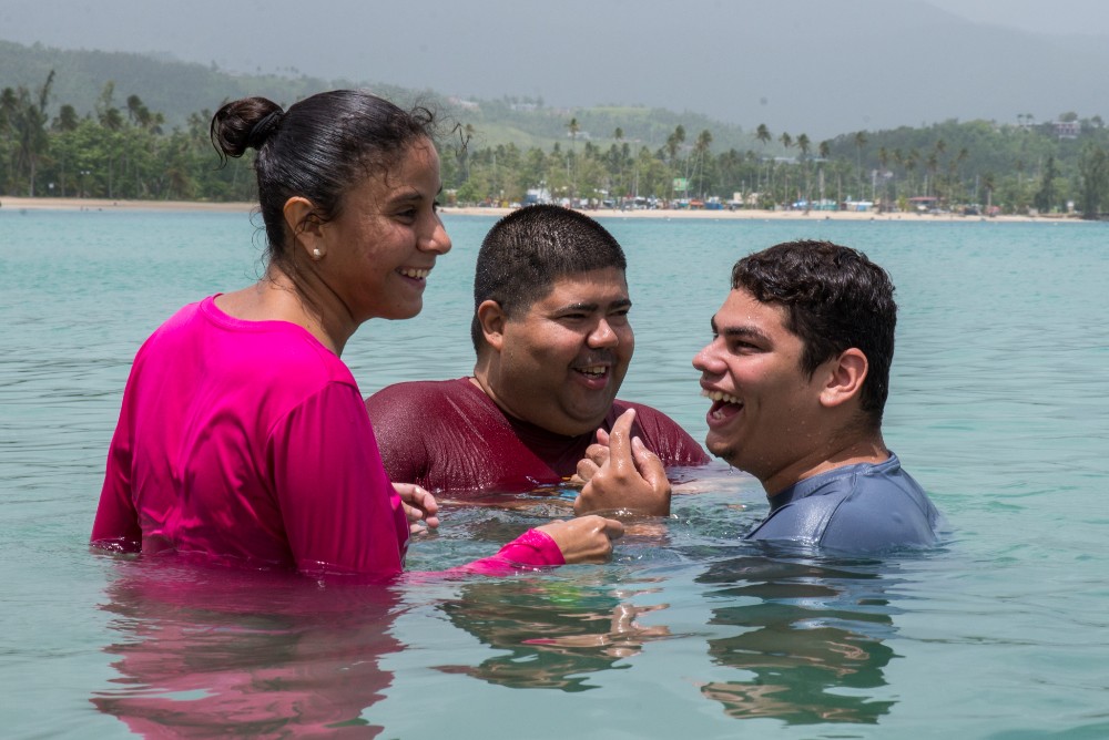  Camp MAVI clients laugh together while swimming at Luquillo Beach. 