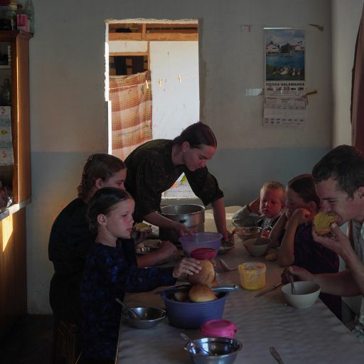 The Schmitt family eat breakfast at home before starting the chores in the fields and around the house. From left to right (Anna Schmitt, 13, Margaretha Schmitt, 7, Elisabeth Schmitt, 15, Susana Schmitt, 18, Benjamin Schmitt, 4, Aganetha Schmitt, 11, Wilhem Schmitt, 21.)

A Mennonite community - a religious ethnic group whose doctrine is based on the Bible as the word of God - has cleared 50 km2 of jungle without permission in Bacalar, in the Mexican Caribbean, today threatened by massive tourism, deforestation and the discharge of sewage into its lagoon. Where previously there were threatened or endangered animal and plant species, now there are colorful wooden houses, transgenic soybean fields, and pig and poultry farms.

This community arrived 20 years ago, from Belize, they traveled to the Mexican southeast in early 2000 and reached Mayan lands, but the indigenous people did not make it easy for them - there was and still is a cultural clash between them - so they settled in Bacalar. Today there are 1,400 inhabitants of this place that they called Salamanca.

When you talk about the contamination of the lagoon and the aquifers in Quintana Roo, they are often pointed out as responsible for what happens in Bacalar, due to their hectares full of transgenic soybeans that they sell to companies in Yucata?n and Campeche. 
Today we see a series of prejudices found between the Mayans and the Mennonites: a peaceful and religious community that does not understand the climate impact and therefore continues to deforest.