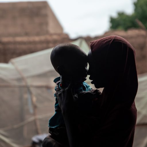 A former Boko Haram child bride with her child embracing each other outside their home in Northern Nigeria.
