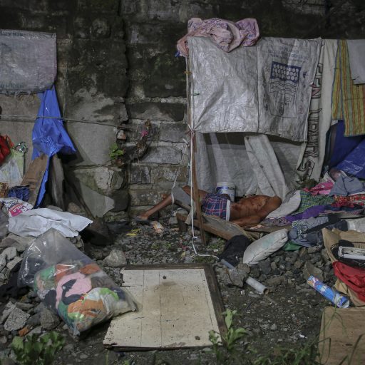 A dead body of an unidentified man lies on a make-shift dwelling on the side of train tracks after an anti-drug operation in Pandacan, Manila on July 21, 2016. Police claim that the man was a drug pusher they were investigating and was only forced to shoot him in self-defense.