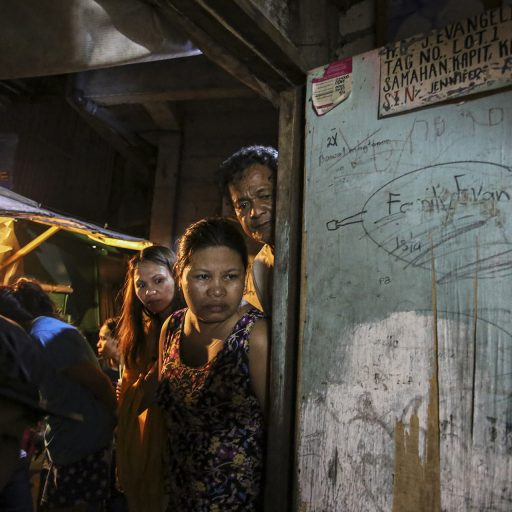 Neighbors look inside the aftermath of a crime scene in Mandaluyong City on November 1, 2016, hours after Manuel Evangelista, Edmar Velarde, Paulo Tuboro, Jennifer Discargar, and Catalino Algueles were massacred by masked men. Evangelista’s daughter said she was in the house with her father and his friends when the killers barged in, made her leave and started shooting.