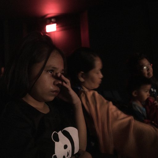 Niña, not her real name, cries inside the theater while watching a play about the war on drugs on August 30, 2019 in Ateneo de Manila University. Niña's parents were killed in front of her and her siblings inside their home in 2016. She was 11 when they were killed. She blames herself, regretting not embracing her mother before they killed her, “maybe they would have spared her if I did”.