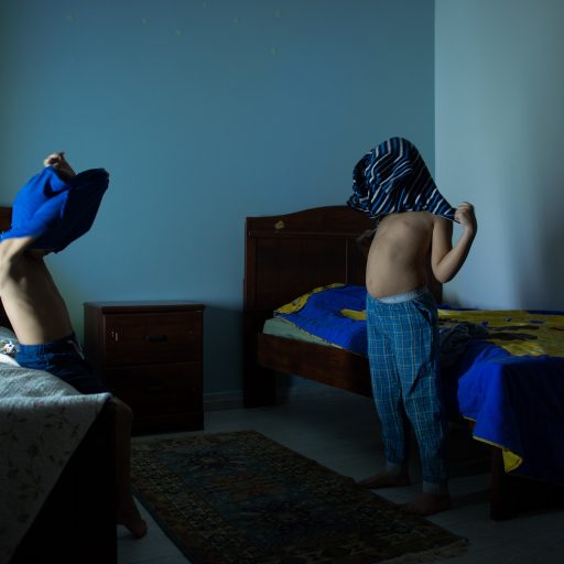 Adel and Mohammed get dressed into their pajamas under LED light during a blackout on July 17, 2020 in Tripoli, Libya. (Photo by Nada Harib/Getty Images)