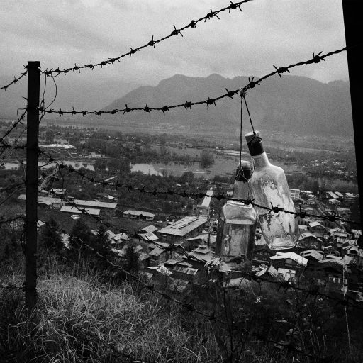 Empty liquor bottles hang on the concertina wire at the foothills of historical Hariparbat fort in Srinagar. On June 26 2014, authorities threw it open for tourists and public. The fort was opened after 24 years.