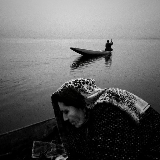 An eldery woman selling fishes on the banks of Dal Lake, Srinagar, Kashmir.