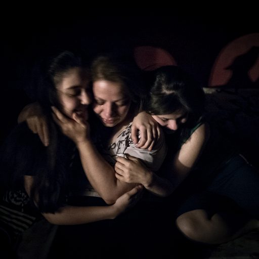 My sisters Yalda and Shadi hug our mother, who weeps out of fear and exhaustion caused by rising debts and our poor financial situation in the wake of my father’s death, in our home in Tabriz, Iran, on September 9, 2014.