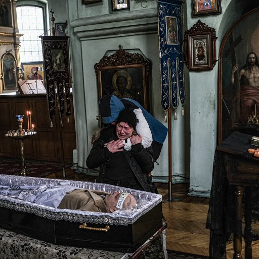 Yelena Herhel is consoled over the body of her husband Arkadiy Yasinsky, in Kyiv, Monday, March 14, 2022. Yasinsky, a civilian, was killed by Russian forces at a military checkpoint in Stoyanka, a village west of Kyiv. ©Byron Smith for VII Mentor Program.