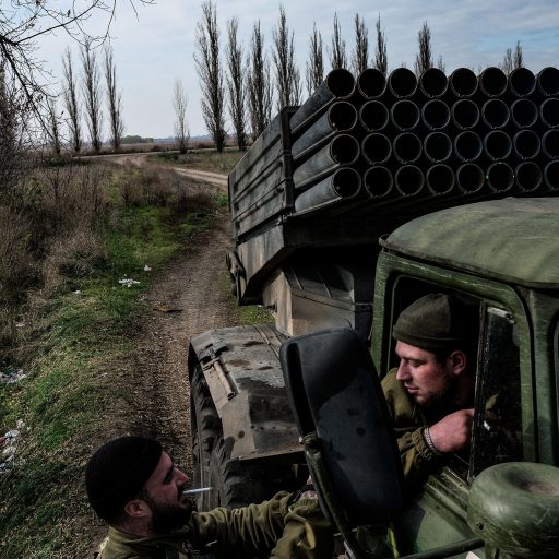 In Ukraine's southern Mykolaiv region, near the front lines, soldiers known by the call signs "Raven," left, and "Gun," wait during a morning pause in rocket firing from a Grad launch system at Russian targets. This occurred as the Ukrainian Armed Forces advanced into the Kherson region on Nov. 3, 2022. ©Byron Smith for VII Mentor Program.