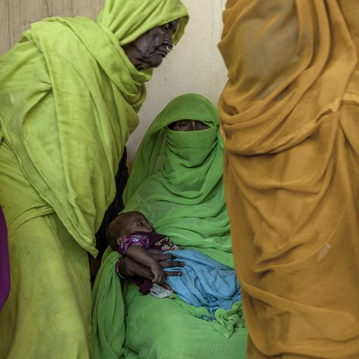 Women wait to be seen by doctors at a community treatment centre for acute malnutrition in Aroma, Sudan on September 26, 2022. Primary healthcare facilities are at the heart of the community. There, pregnant women and new mothers receive their cash grants and benefit from a bundle of integrated services, from health and nutrition, sanitation to birth registration and protection. © Adriana Zehbrauskas for UNICEF.