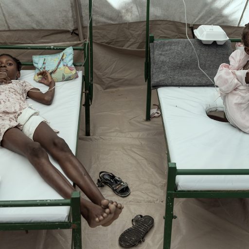 Woodbine Badette, 10 (on the left) in the pediatric tent at the  MSF (Medicines Sans Frontieres) Cholera treatment Center in City Soleil, Haiti, on Saturday, November 12, 2022. © Adriana Zehbrauskas.