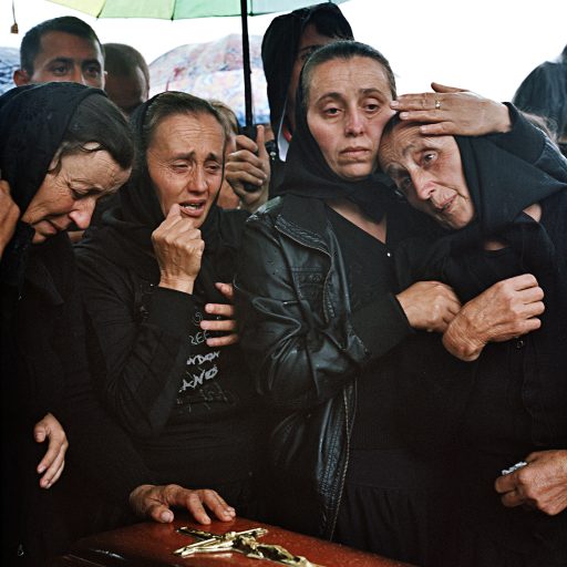 Irina Veciunca is comforted at the burial of her husband, Ștefan, who died in June 2012 in Poienili de sub Munte. Maramures, Romania. June, 2012. © Rena Effendi.