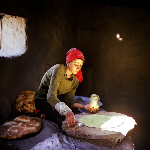 Sadaget bakes bread in a tandoor oven at home in Khinaliq village, Azerbaijan’s highest populated point where about 1000 shepherd families have settled at an altitude of 2350 meters above the sea. Archeological evidence suggests that Khinaliq has been inhabited for over five millennia. People speak the endangered language of Khinaluq, which has already lost its written form. Like all other women in the village, Sadaget’s life is deprived of domestic comforts since even basic amenities are absent in the village. There is no running water, but the springs nearby and no gas supply in the kitchens. Women mostly stay home looking after the family household while the men graze their sheep flocks in the mountain pastures around the village. Khinaliq Village, Azerbiajan. 2006. © Rena Effendi.