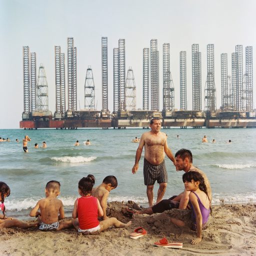While most of the beaches in the Baku coast-line have been privatized, Shikhov beach, about 20 minutes by car south-west of the Baku city center is one of the few remaining public (free access) beaches in close vicinity of the city. Soviet era oil rig structures are stagnant in the background. Baku, July 2016. © Rena Effendi.