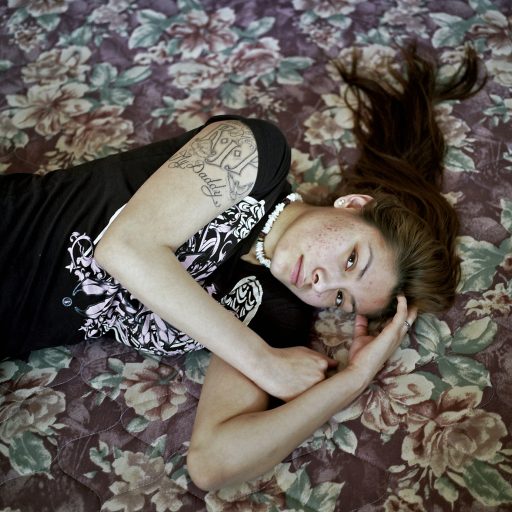 Felicia Owlboy, age 19, at her aunt Jada's home in St. Michaels. The tattoo on her arm is dedicated to her father who hung himself. Spirit Lake, North Dakota. April, 2013. © Rena Effendi.