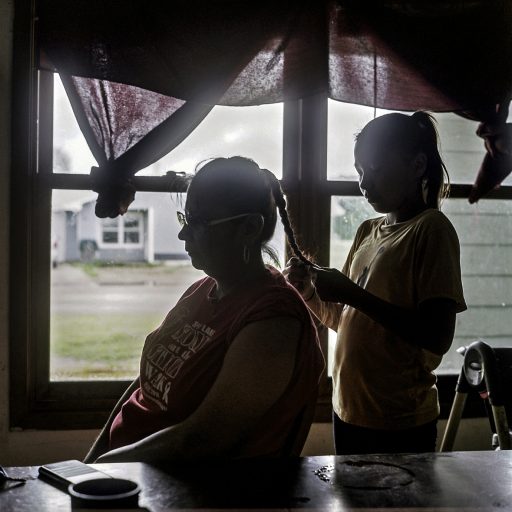 Jordyn braids her mother Jayda's hair in the morning at grandpa Frank's home in St. Michaels. Spirit Lake. August 2018. © Rena Effendi.