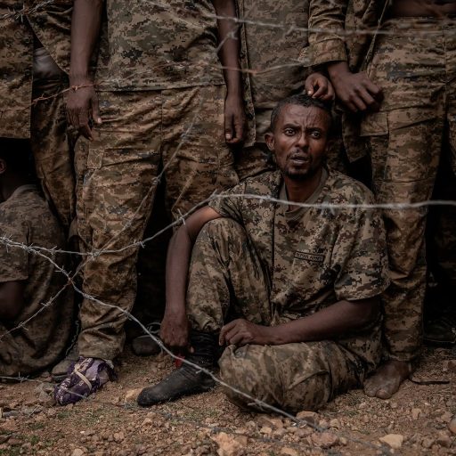 Captured Ethiopian government soldiers at a prisoner of war camp in the mountains of Tigray in June, 2021. Some 6,000 government troops were captured by the Tigray People's Liberation Front, during fighting  in Ethiopia's northern Tigray region. Fighting broke out in Tigray in November, 2020 when the government accused the TPLF of attacking military bases across the region, which the party denied. The civil war has drawn in neighboring Eritrea on the side of the Ethiopian government, and has been marked by atrocities, starvation, and allegations of war crimes by both sides. The government declared victory three weeks into the conflict when it took control of the regional capital Mekelle, but the Tigrayan guerrilla army known as the Tigray Defense Forces (TDF) retook Mekelle and most of Tigray at the end of June, after the government suffered a cascade of battlefield loses. Thousands of people have died in the fighting; around 2 million have been displaced and more than 5 million rely on food aid.  © Finbarr O’Reilly.
