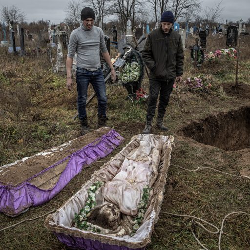 Local residents help police and war crimes investigators exhume the body of Viktoria Volokhova, a 15-year-old girl who local residents said had been executed by Russian forces, along with seven men, six of whose bodies had been exhumed the day before from the garden of a nearby house, in the recently liberated southern Ukrainian village of Pravdyne, November 29, 2022. Eight people were killed at the house when an informant told Russian forces the civilians were passing on information to Ukrainian military sources, according to local residents. The bodies were found with some of their hands tied, their eyes blindfolded, and shot at close range in the back of the head. Afterwards the house was blown up and the bodies were later buried in a grave beside the house by a local resident. © Finbarr O’Reilly.