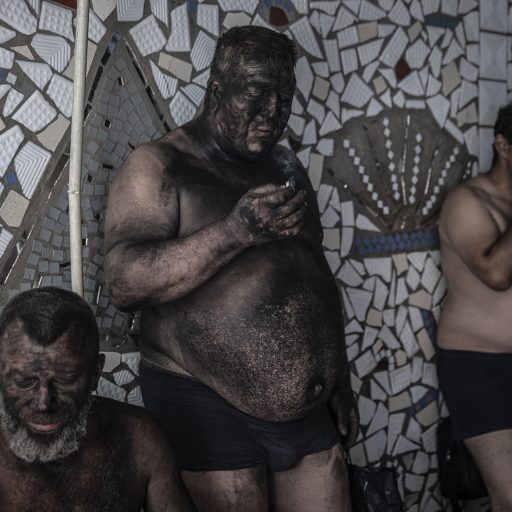 Miners smoke before taking a shower after a 6-hour shift at 1/3 Novogrodivska state-run coal mine, near the town of Selidove, in Ukraine’s eastern Donetsk region, June 8, 2022. © Finbarr O’Reilly.