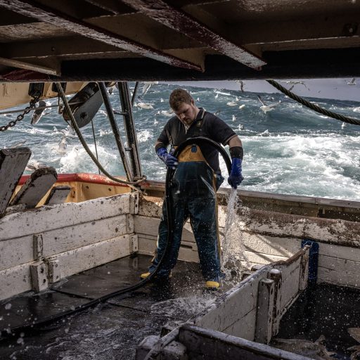 Cleaning the deck aboard the trawler Eblana on the Irish Sea, October 24, 2023. A decade ago there were dozens of trawlers operating out of my home fishing port of Howth. The Eblana is now the only one left.  © Finbarr O’Reilly for the Pulitzer Center for Crisis Reporting.