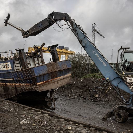 A scrapyard in New Ross where newly decommissioned fishing vessels are torn apart, October 26, 2023. The fleet of Irish fishing vessels is scheduled to undergo a controversial government decommissioning scheme to reduce by about 30% the number of Irish fishing boats operating in local waters. © Finbarr O’Reilly for the Pulitzer Center for Crisis Reporting.