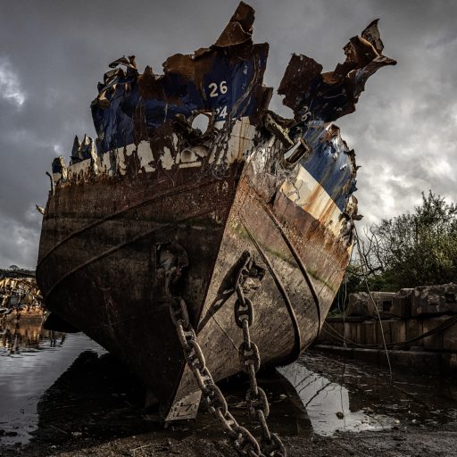 A scrapyard in New Ross where newly decommissioned fishing vessels are torn apart, October 26, 2023. The fleet of Irish fishing vessels is scheduled to undergo a controversial government decommissioning scheme to reduce by about 30% the number of Irish fishing boats operating in local waters. © Finbarr O’Reilly for the Pulitzer Center for Crisis Reporting.