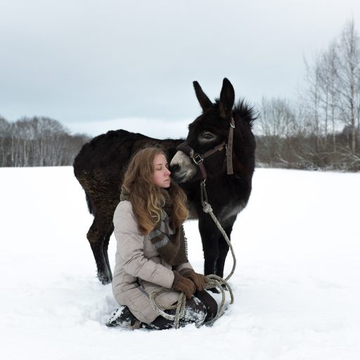 Lisa, a volunteer, with a donkey on a walk. She has been at Svetlana Village for nearly two years. She worked in the bakery, took care of the donkey and worked on the farm. Young people from different countries often come to live and work in the village. ©Mary Gelman.
