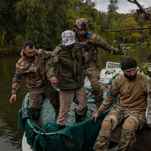Ukrainian soldiers are seen escorting a captive, named Aleksandr, 69, on to the west bank of the Siverskyi Donets River, near Lyman, Ukraine, on Tuesday, September 27, 2022. Ukrainian soldiers captured him on the frontline, and believe he is a spy for Russian forces. Ukrainian forces recaptured the resort village of Szczurowe, on the eastern side of the Siverskyi Donets River, 10 days ago, and are attempting to recapture the town of Lyman from the south and western sides. © Nicole Tung.