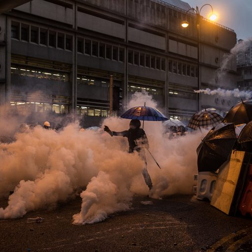 A protestor throws a tear gas canister back at the riot police in Tsuen Wan neighborhood in Hong Kong, S.A.R. on August 25, 2019 following the end of a rally in which thousands participated. Over the last 12 weeks, violence has escalated as protesters attempt to find new ways to keep their demands alive.

Since June 2019, large scale protests have taken place in the special administrative region of Hong Kong. Initially, the protests were held to demand the withdrawal of the extradition bill that would have allowed suspects from Hong Kong to be extradited to stand trial in China, but have grown into pro-democracy demonstrations in a rebuke to the local government's handling of the crisis. It has also expanded to include social grievances and a criticism of China's encroachment on the freedoms of Hong Kong people. Over the past 12 weeks, protestors have repeatedly marched in rallies to reiterate their five main demands including a full withdrawal of the controversial extradition bill, the retraction of the government's characterization of protests as “riots" as well as calling for the unconditional release of all arrested protesters, universal suffrage, and an inquiry by an independent commission into all events since June. Protestors also voiced their concerns over the excessive force used by police against the demonstrators, which have also affected regular citizens in the city. © Nicole Tung.