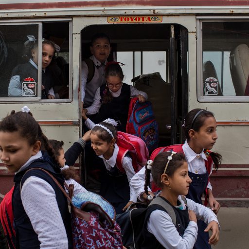 Schoolchildren exit a bus in western Mosul, Iraq. Since Mosul was declared liberated by the Iraqi forces four months ago, some schools have reopened in the city where many children have missed years of their education. November 2017. © Nicole Tung.