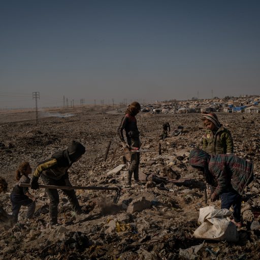 Children sort through waste for plastic and metal scrap to collect before selling, at a dumping ground opposite the Sahel al Banat camp for internally displaced persons in Raqqa governorate on Saturday, February 5, 2022. Many of the camp’s residents had been there for at least one to two years, with some having fled from areas under the Syrian government’s control. The camp houses several thousand people, living in derelict conditions with minimal support from aid organizations, and no school for older children. Most women and children work in sorting waste at the dumping ground opposite the camp, while the men work as shepherds raising livestock to sell. The area’s high rates of poverty have made the population susceptible to recruitment by ISIS militants, according to the Syrian Democratic Forces, who recently arrested 27 people with suspected links to ISIS in Raqqa’s eastern countryside, including in this camp, and other villages. 

Last month, the Islamic State of Iraq and Syria launched its largest attack since their territorial defeat in Baghouz nearly three years earlier, on the Ghwaryan prison in Hasakah, Syria. In a surprise attack that appears well-planned, dozens of Islamic State members on the outside launched a prison break to free ISIS leaders, it is believed. The extremist group has been laying the groundwork for their resurgence since 2019, using sleeper cells in sparsely populated areas particularly in Deir Ezzor, Hasakah, and Raqqa Governorates to stage attacks on security forces, instilling fear in the local population, while recruiting people by exploiting the economic frailty of communities who have been ravaged by war. By staging hit and run attacks on bases, checkpoints, and assassinating local council leaders, ISIS’s omnipresence is felt in the region despite not physically existing in any one place. © Nicole Tung.
